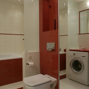 W łazience dominuje kolor biały, ale dodatek czerwieni jest bardzo wyraźny. Obfite oświetlenie sprzyja temu wnętrzu, gdyż wszystkie powierzchnie wykonane zostały  „na połysk”. Fot. Monika Filipiuk.