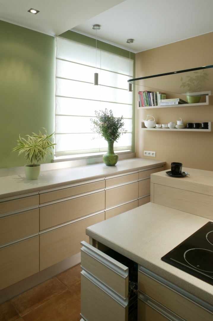 Kuchnia została zaaranżowana w świeżych i jasnych kolorach. Meble z białego dębu milano wykończono aluminiowymi detalami. Fot. Monika Filipiuk.