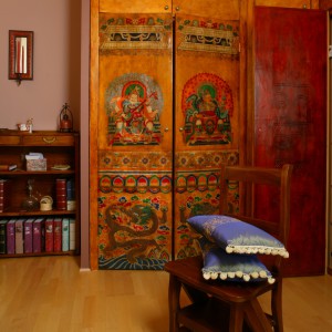 Dzięki pojemnej szafie sypialnię można traktować również jako pokój garderobiany. Na wykonanych ze starego parawanu drzwiach mebla, widnieje wizerunek tybetańskich królów. Fot. Monika Filipiuk. 