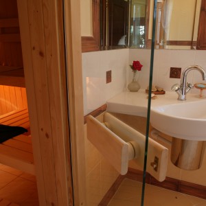 Na ławkach w saunie można oddawać się kąpieli leżąc lub siedząc. Nastrojowe światło lamp i szklane drzwi dają poczucie większej przestrzeni.
 Fot. Monika Filipiuk.