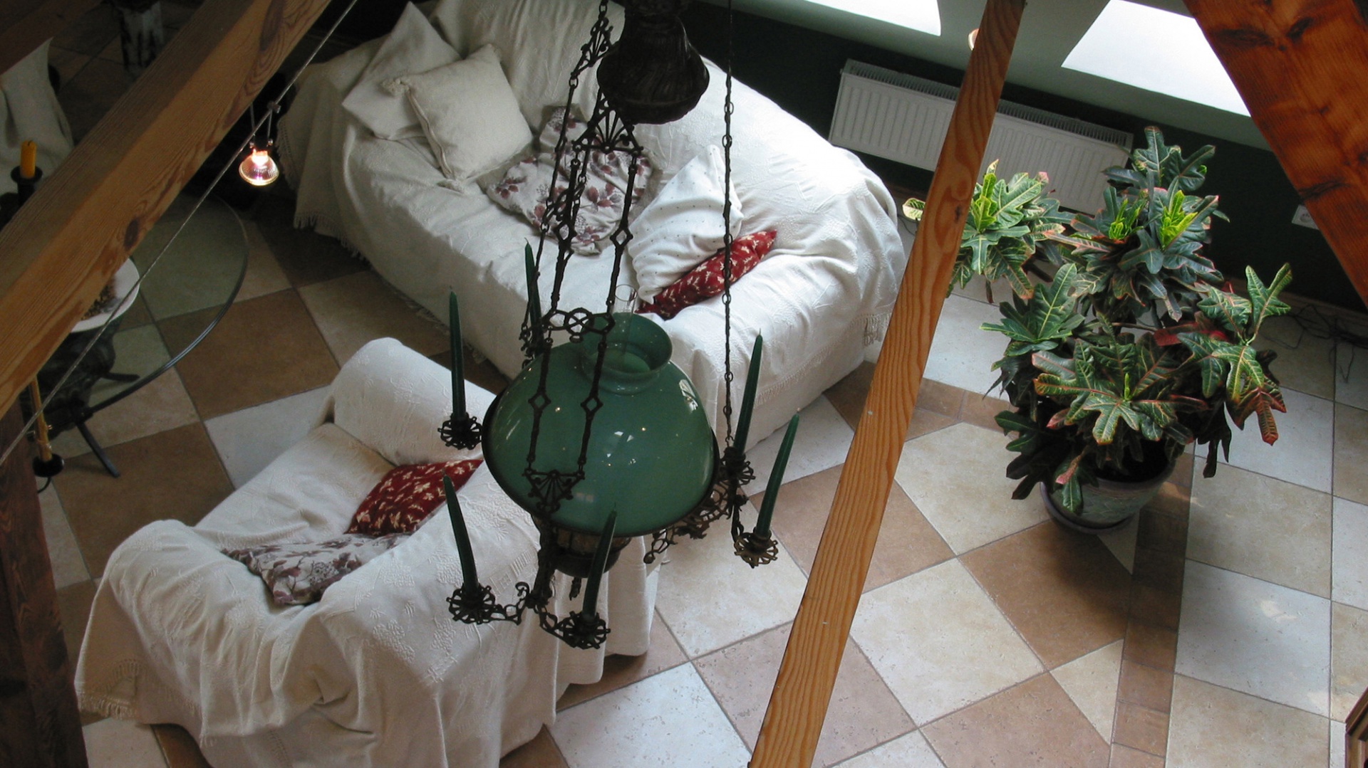 Widok na salon z antresoli. Nad wnętrzem czuwa oryginalna dziewiętnastowieczna lampa z fantazyjnymi, żeliwnymi zdobieniami i miejscami na świeczki. Obok tego właściciele postanowili umieścić zupełnie współczesne sznury halogenowych lampek. Fot. Tomek Markowski.