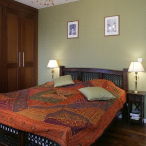 Patchworkowa narzuta na łóżko wypełnia sypialnię „orientalnymi” kolorami. To za jej sprawą, nie tylko małżeńskie łoże, ale też całe wnętrze nabiera wyjątkowego charakteru. Fot. Monika Filipiuk.