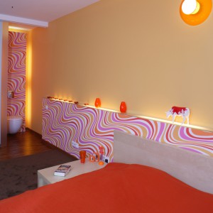 Soczyste kolory i falujący wzór na tapecie stały się inspiracją aranżacji całej sypialniano-łazienkowej przestrzeni. Fot. Monika Filipiuk.