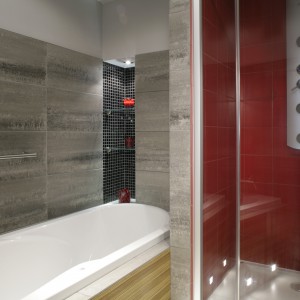Krwistoczerwone płytki wypełniają całe wnętrze kabiny prysznicowej. Są kontrapunktem dla oryginalnej, acz spokojnej aranżacji otoczenia znajdującej się obok wanny. Fot. Monika Filipiuk.