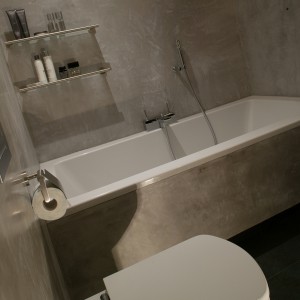 Wszystkie ściany oraz zabudowę wanny w łazience wykończono stiukiem o fakturze mokrego betonu. Następnie na ich powierzchnie nałożono specjalną warstwę wosku, która powoduje, że ściany są wodoszczelne i można je myć, jak np. płytki ceramiczne. Fot. Tomasz Markowski.