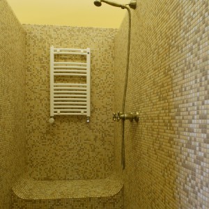Wnętrze kabiny prysznicowej w całości pokryte jest szklaną mozaiką. Podczas natrysku można spocząć na wymodelowanym obszernym siedzisku. Fot. Monika Filipiuk.