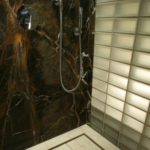 Oryginalny brodzik w kabinie prysznicowej zrobiony został z dwóch płyt marmuru. Woda spływa przez szczeliny wokół jednej z nich. Fot. Bartosz Jarosz.