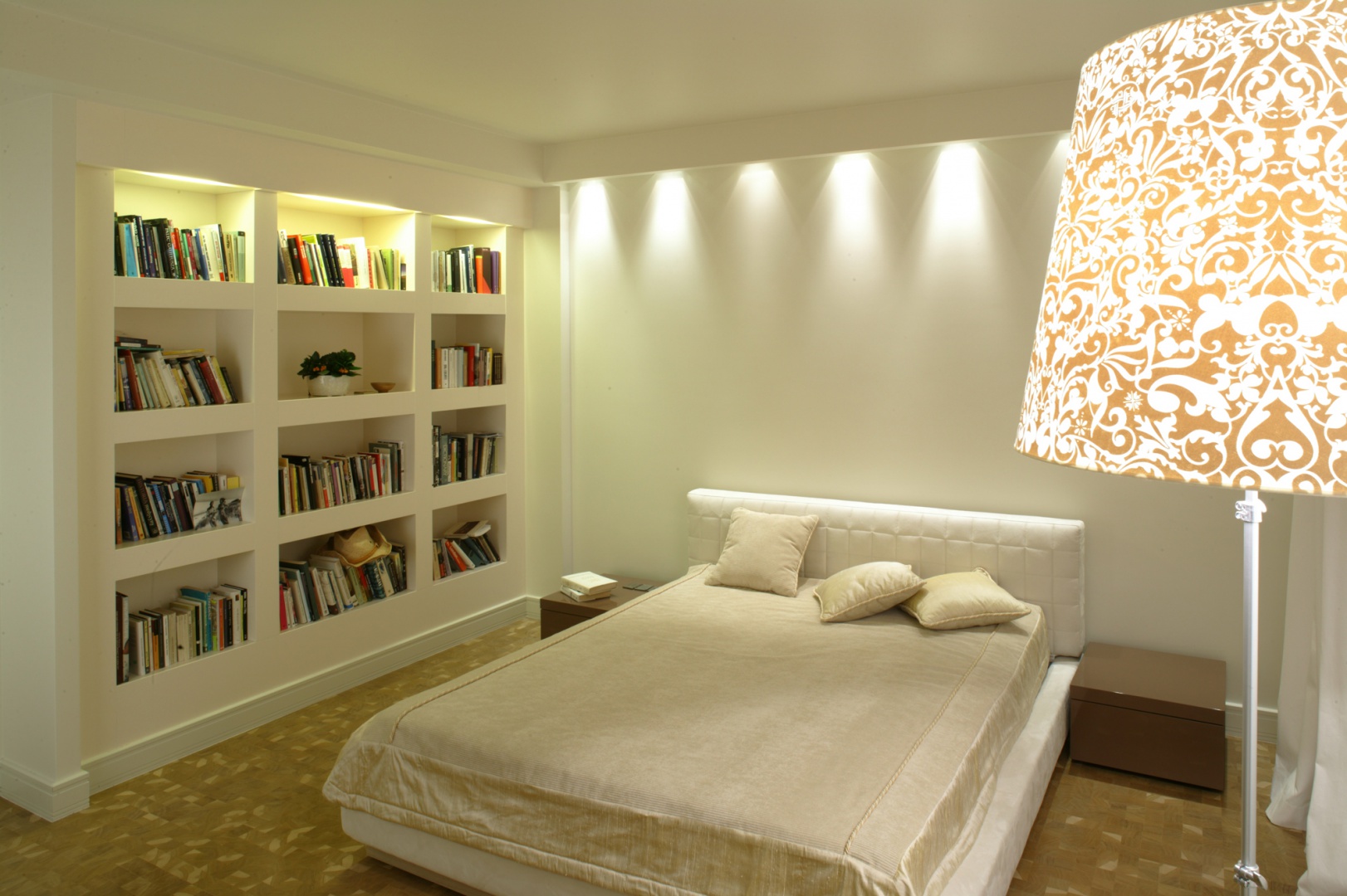 Łóżko z pikowanym zagłówkiem to wytworny akcent nowoczesnej i minimalistycznej sypialni. Mebel wyeksponowany został za pomocą światła, które wydobywa się z ukrytych w sufitowym gzymsie halogenów. Fot. Monika Filipiuk.