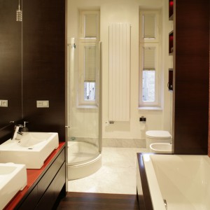 Biały kolor ceramiki łazienkowej oraz przezroczysta szklana kabina prysznicowa idealnie wtapiają się w tło  jasnych ścian i  marmurowej posadzki. Tworzą trzecią część łazienkowego tryptyku. Fot. Bartosz Jarosz.