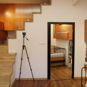 Schody w górę to kolejny żart architekta. Prowadzą donikąd. Wyżej nie ma już  żadnego pomieszczenia. Pod nimi, od korytarza, biegną schody w dół do sypialni gospodarzy. Tutaj zaś, po wyjściu na spocznik, uzyskuje się dostęp do podsufitowej garderoby z ukrytym systemem wnęk i półek.  Fot. Bartosz Jarosz.