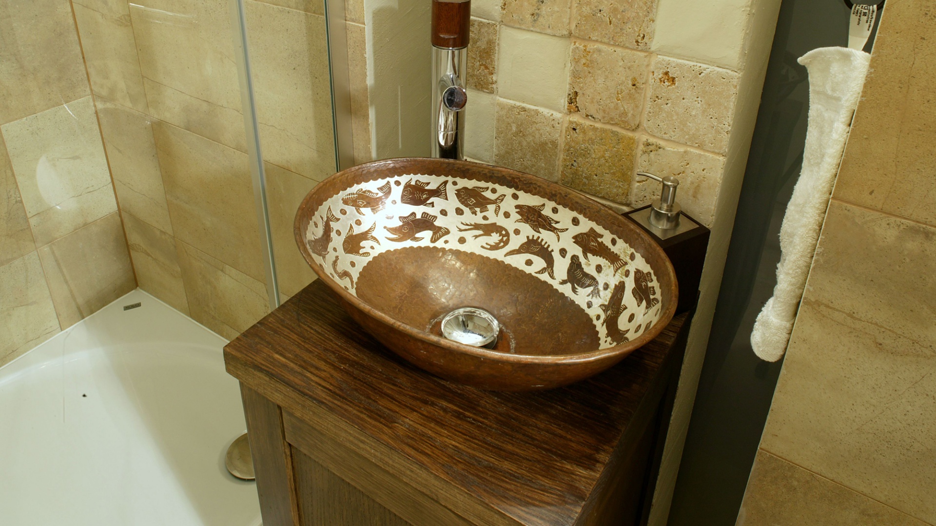 Bateria z uchwytem z drewna orzechowego świetnie pasuje do brązowej ceramicznej misy i wybarwionej na orzech szafki. Wyprodukowała ją firma Tres. Fot. Monika Filipiuk.