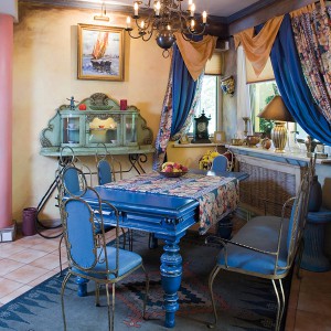 Do starych mebli (witrynka i stół) doprojektowano lekkie, stalowe krzesełka i kanapę, które obito niebieską tkaniną. Fot. Bartosz Jarosz.