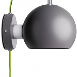 Lampa ścienna Ball marki BoConcept dostępna w trzech wersjach kolorystycznych. Świetnie sprawdzi się w nowoczesnych sypialniach.Na zdjęciu kinkiet wykonany z ciemnoszarego metalu z przewodem z zieloną powłoką tekstylną. Fot. BoConcept