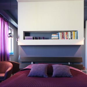 Śliwkowe, intensywne fiolety obecne we wszystkich dodatkach tej sypialni doskonale prezentują się na tle fiołkowych ścian. Projekt Arkadiusz Grzędzicki Fot. Bartosz Jarosz