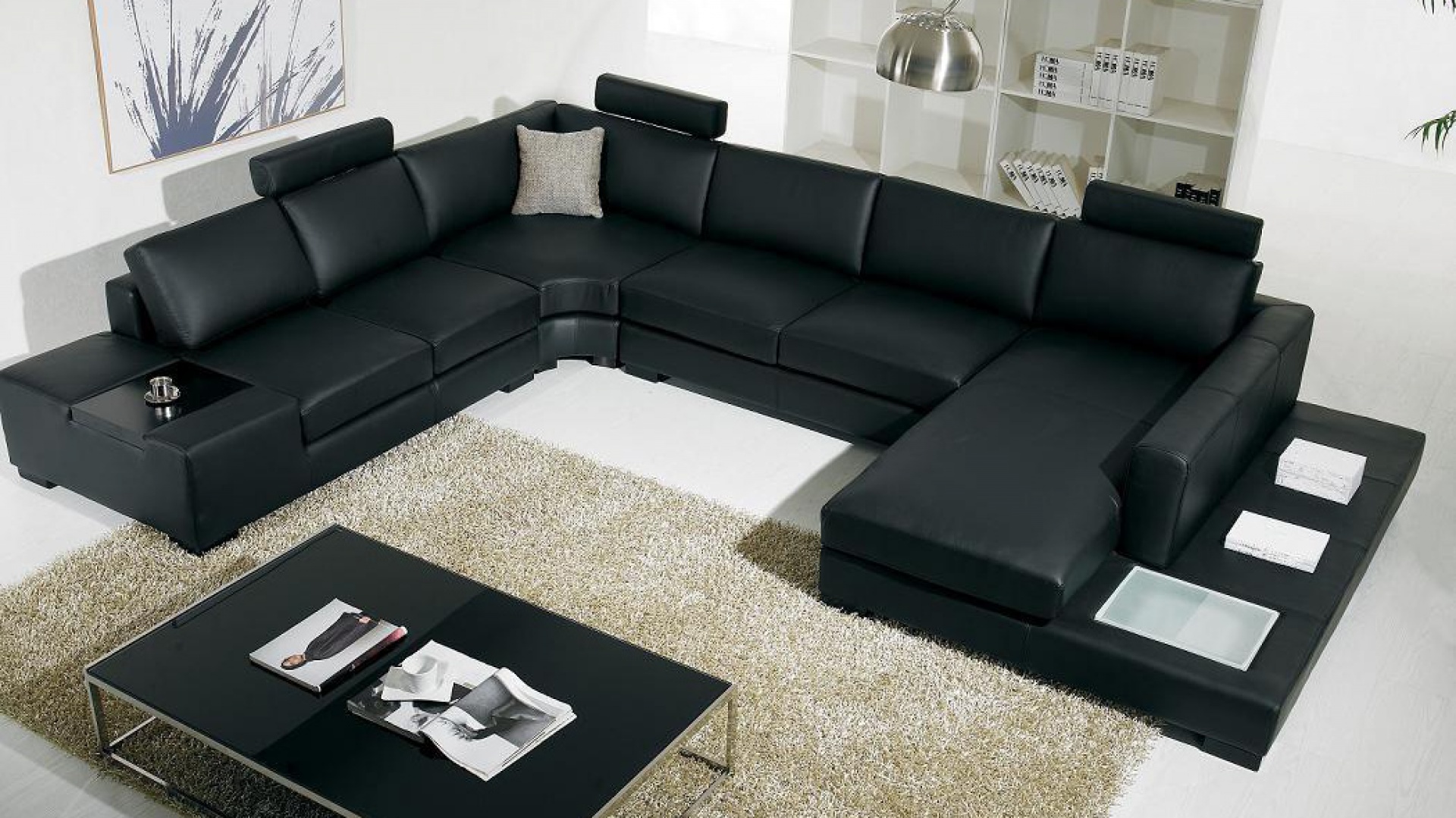 Czarną, dużą sofę w kształcie podwójnej litery L można wyznaczyć granicę salonu. Fot. agcinteriordesign.info.