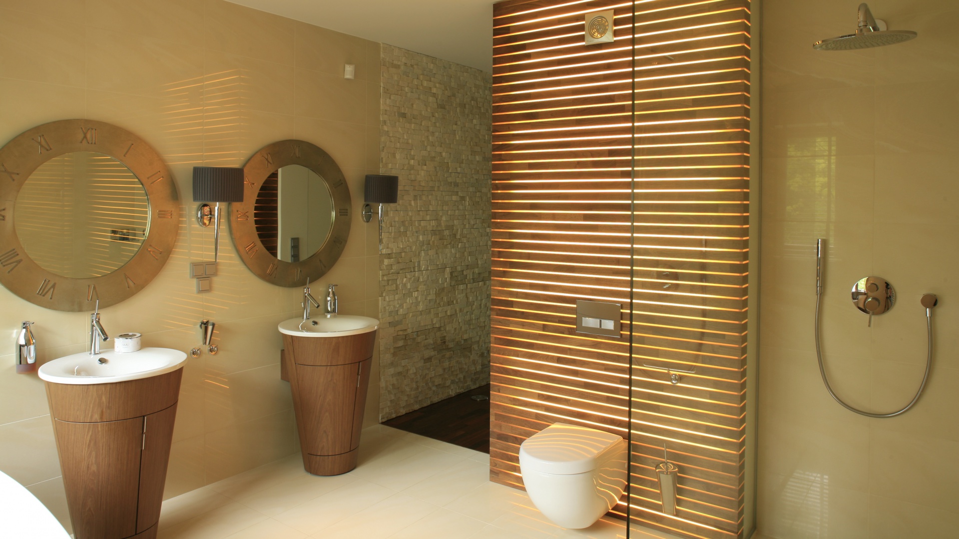 Utrzymana w ciepłych beżach i jasnych brązach łazienka stylistyka nawiązuje do salonu SPA. Świadczą o tym zarówno drewniane elementy, jak i ich ozdobne formy. Łazienka Jest na tyle duża, że bez problemu zmieściły się w niej dwie umywalki, wygodna wanna i równie wygodny prysznic. Projekt Paweł Ejsmont. Fot. Bartosz Jarosz.