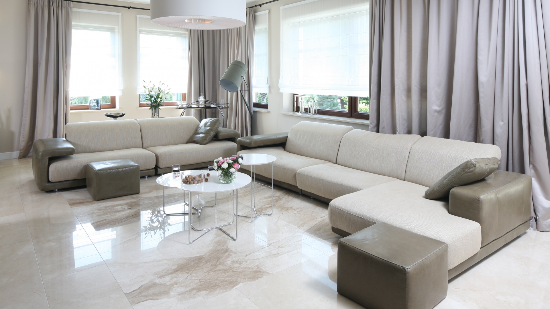 Elegancki salon zdominowały jasne barwy obecne zarówno w kolorystyce ścian i podłóg, jak i wyposażenia: eleganckich kanap, stylowy zasłon oraz nowoczesnych stolików czy lamp. Projekt: Katarzyna Koszałka. Fot. Bartosz Jarosz.