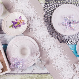 Biała, zdobiona porcelana w zestawieniu z białymi, dekoracyjnymi kwiatuszkami, przywodzącymi na myśl płatki śniegu. Fot. Home&You. 