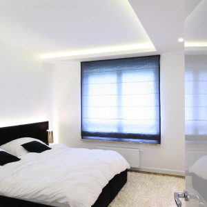 Delikatnie podświetlony sufit wprowadza do minimalistycznej sypialni ciekawy akcent. Projekt: Agnieszka Hajdas-Obajtek. Fot. Bartosz Jarosz.