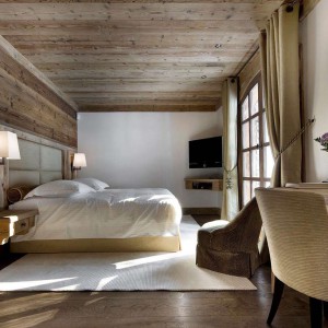 Sufit i ściana za łóżkiem z wyraźnym rysunkiem drewna. Fot. Gentianes/ Alpine Guru.