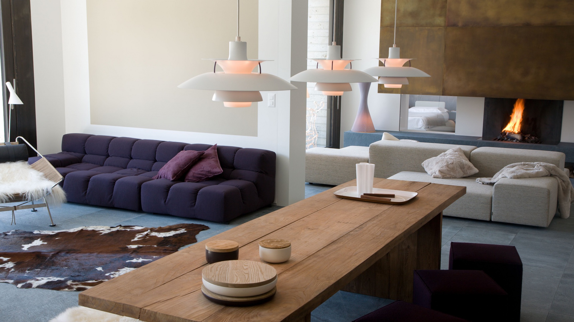 Apartament urzeka przytulnym wystrojem. Miękkie meble wypoczynkowe, futerkowe narzuty na drewniane meble i dywan ze zwierzęcym motywem nadają wnętrzu ciepły klimat. Kominek w salonie zachęca do spędzenia przy nim mroźnych, zimowych wieczorów. Projekt: arch. Laura Consiglio, arch. Francesca Menga / Carlo Donati Studio. Fot. Carlo Donati Studio.