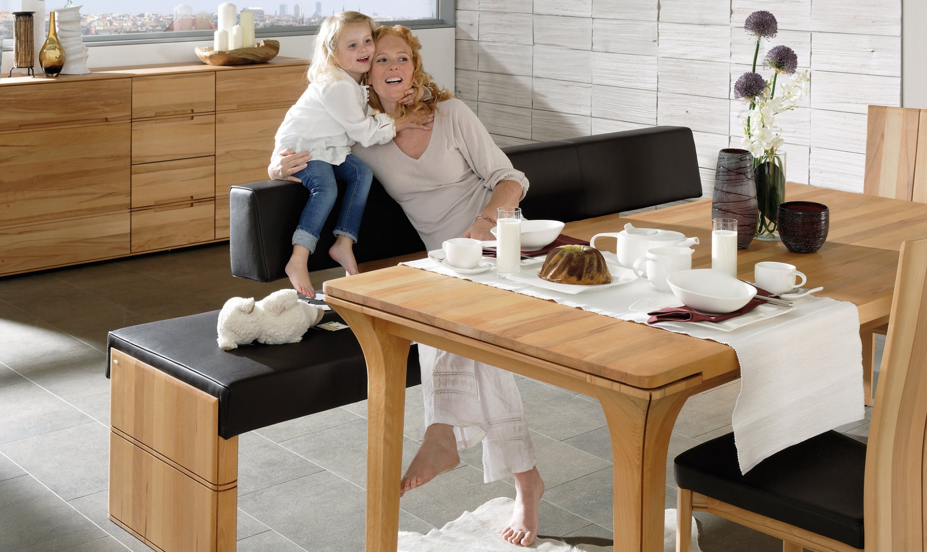 Meble z litego drewna z kolekcji V-Soft marki Voglauer to połączenie elegancji z nowoczesnością. Dzięki wyłożeniu siedzisk krzeseł i ławki czarną skórą zestaw zyskał nowoczesny wygląd. Fot. Voglauer.
