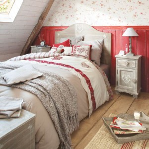 Delikatne, bordowe wzory na tkaninach dodają sypialni uroku. Ciekawie prezentuje się ściana za łóżkiem - połączenie intensywnej barwy z delikatną, wzorzystą tapetą. Fot. Maison du Monde. 