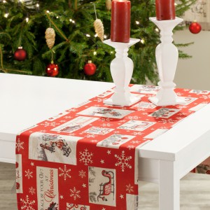 Czerwony obrus bieżnik ze świątecznym motywem to propozycja dla osób lubiących wesołe aranżacje stołu. Ciepłe kolory, świąteczne obrazki i okalające je zimowe śnieżynki będą miłych i prawdziwie świątecznym akcentem na bożonarodzeniowym stole. Fot. Dekoria. 