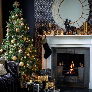 W tej szykownej, eleganckiej dekoracji domu na Święta, czarna figurka renifera dumnie stoi nad kominkiem. Dekoracja harmonizuje z czarną skarpetą na prezenty i wpisuje się w ciemną kolorystykę ścian. Fot. House of Fraser.