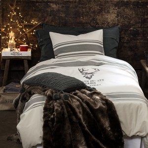 Pościel z nadrukiem głowy renifera idealnie pasuje do tej delikatnie surowej świątecznej aranżacji. Fot. H&M Home.