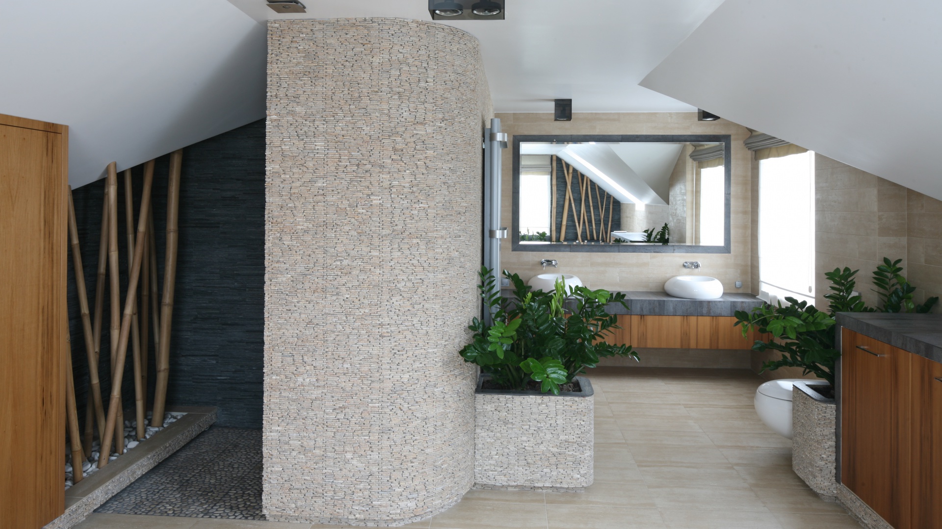 W pięknym, przestronnym salonie kąpielowym w stylu SPA rolę pierwszoplanową odgrywają materiały: zastosowano kilka rodzajów kamienia, w tym kamienną łupankę. Wraz z roślinami zielonymi tworzy scenerię idealną do relaksu. Projekt: Karolina Łuczyńska. Fot. Bartosz Jarosz.