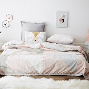 Pastelowe, geometryczne wzory prezentują się bardzo lekko w sypialni. Fot. Oyoy Design/Norsu.