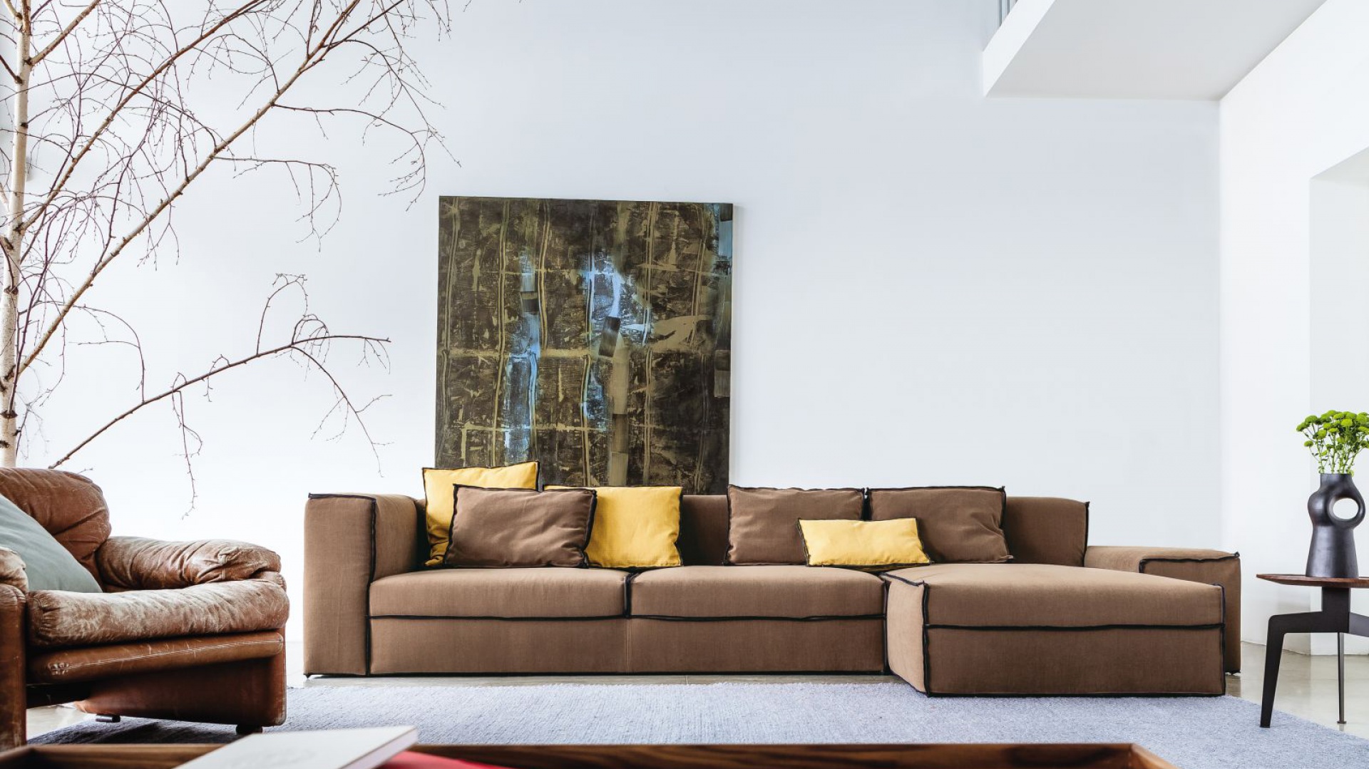 Obszerna sofa X-Small marki Lomidesign. Nowoczesne, proste kształty mebla zostały podkreślone czarnymi obszyciami krawędzi. Fot. Lomidesign.