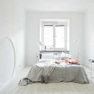 Białe, wysokie lampy podłogowe umieszczone po obu stronach łóżka stają się prawie niewidoczne na tle białych ścian. Fot. Fantasik Frank.