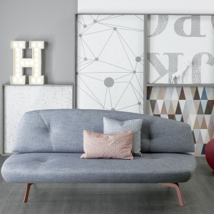 Niewielka, szara sofa Bandy o anatomicznym kształcie. Zmysłowy charakter mebla podkreślają cienki nóżki w beżowym kolorze. Fot. Bonaldo. 
