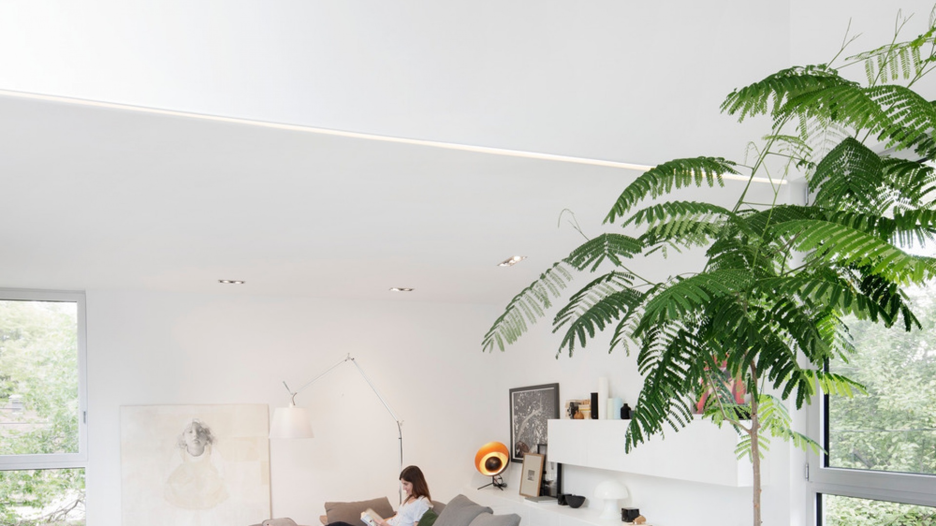 Salon z wysokim sufitem zyskuje dodatkowe wrażenie przestronności dzięki jasnym barwom, które zdominowały jego przestrzeń. Projekt: Thomas Balaban Architecture. Fot. Adrien Williams.