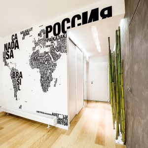 Ściana w salonie została udekorowana mapą świata, ułożoną z nazw poszczególnych państw, zapisanych różnymi alfabetami. Projekt i zdjęcia: Brain Factory.