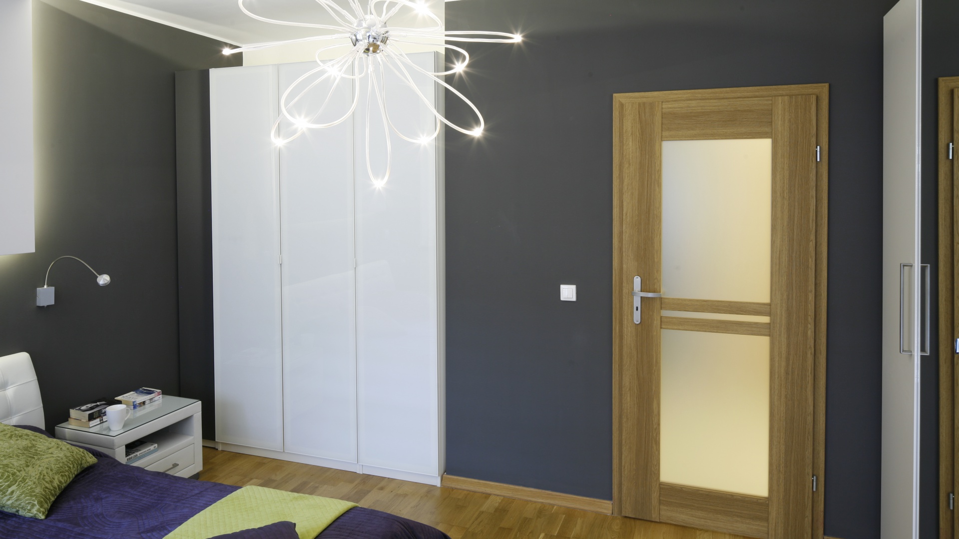 Ultra nowoczesna lampa przypominająca skupisko tańczących świetlików wygląda niezwykle lekko, dzięki czemu dość ciemna aranżacja zyskuje subtelny wygląd. Projekt: Marta Kilan. Fot. Bartosz Jarosz.