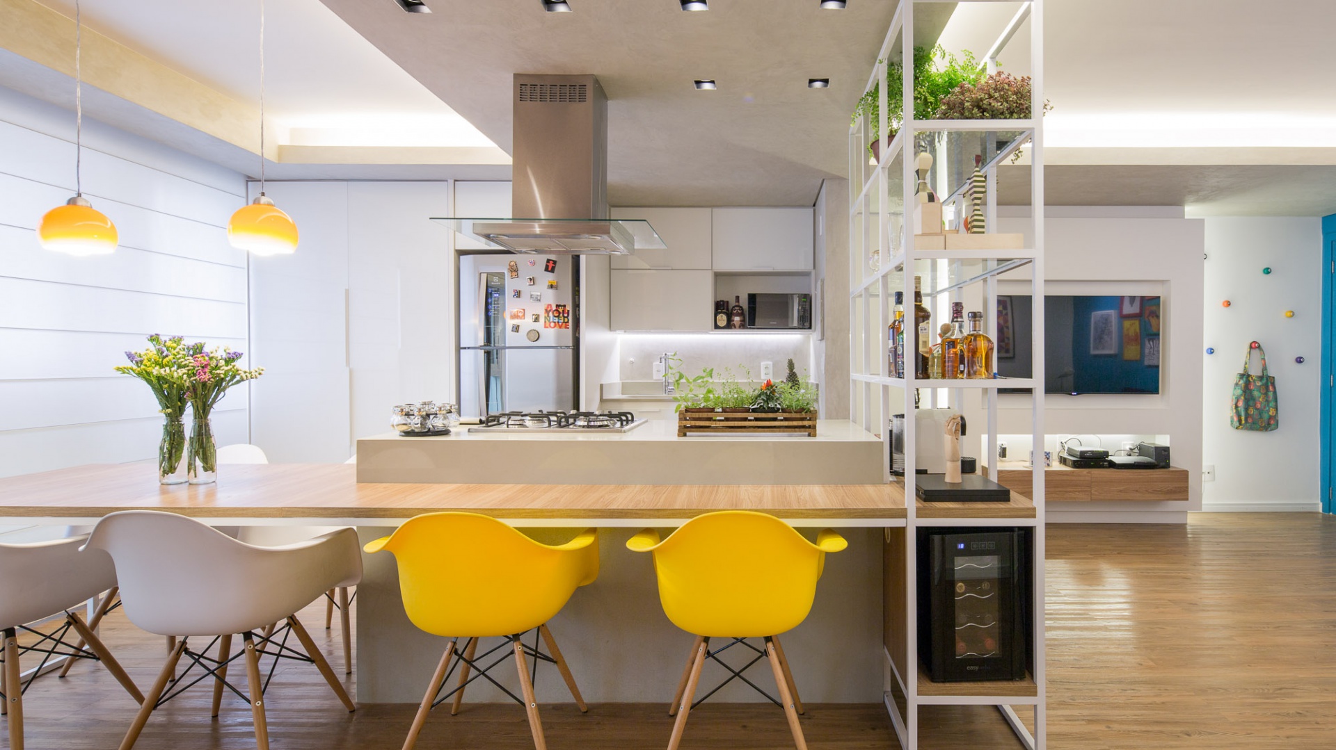 Centralnym punktem całego mieszkania jest wyspa, połączono ze stołem jadalnianym na 6 osób. Projekt: Semerene Arquitetura Interior. Fot. Joana França.