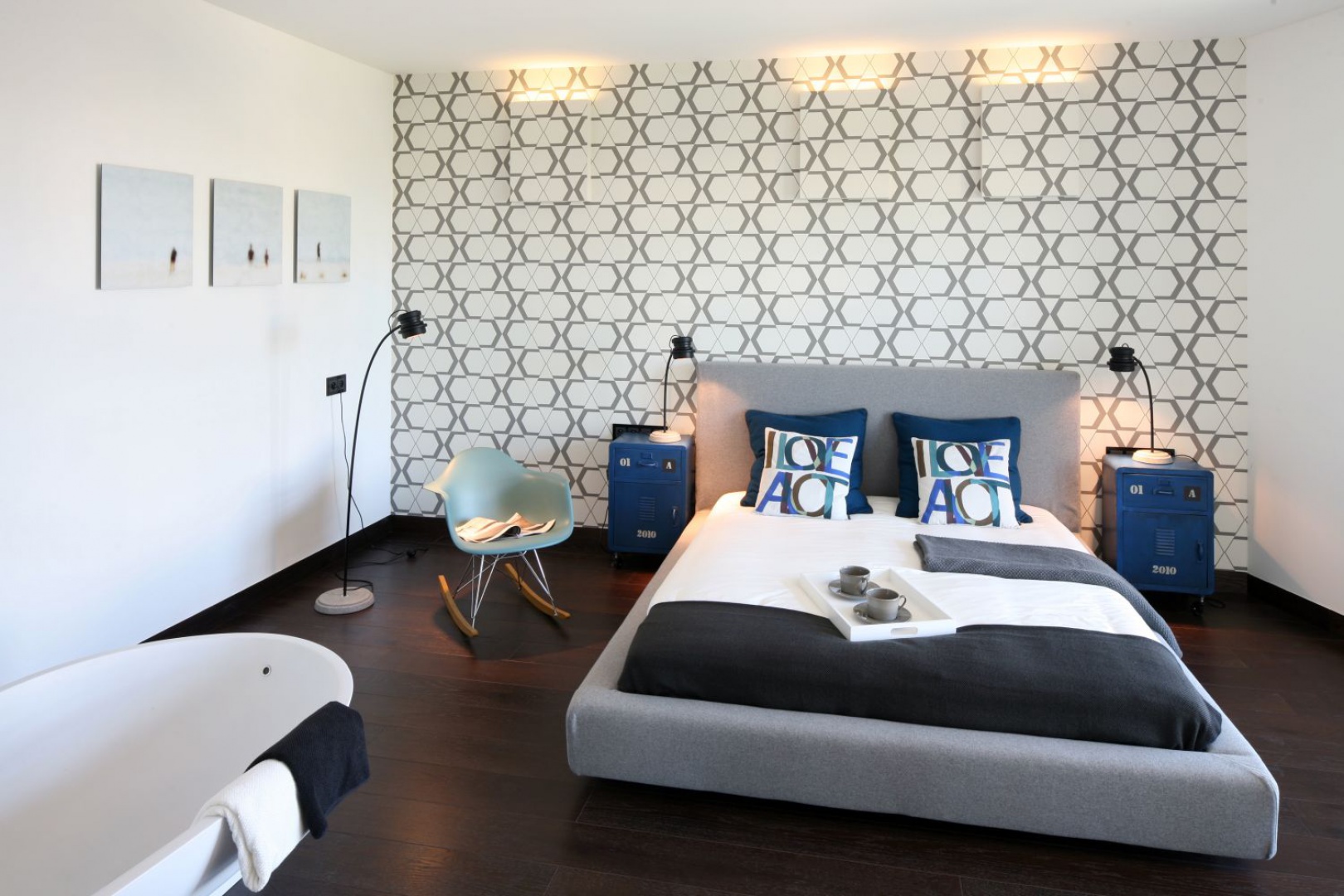 Przestronną sypialnię urządzono w stylu loft. Dominują tu szarości obecne zarówno na designerskie tapecie, jak i meblach i dodatkach. Projekt: Justyna Smolec. Fot. Bartosz Jarosz.