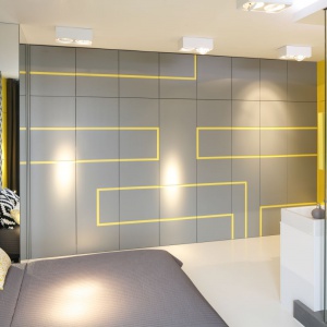 Żółty „labirynt” prowadzący przez szare ściany nadaje ostrości wnętrzu. Wyjściem z labiryntu są drzwi po przeciwległych stronach sypialni.