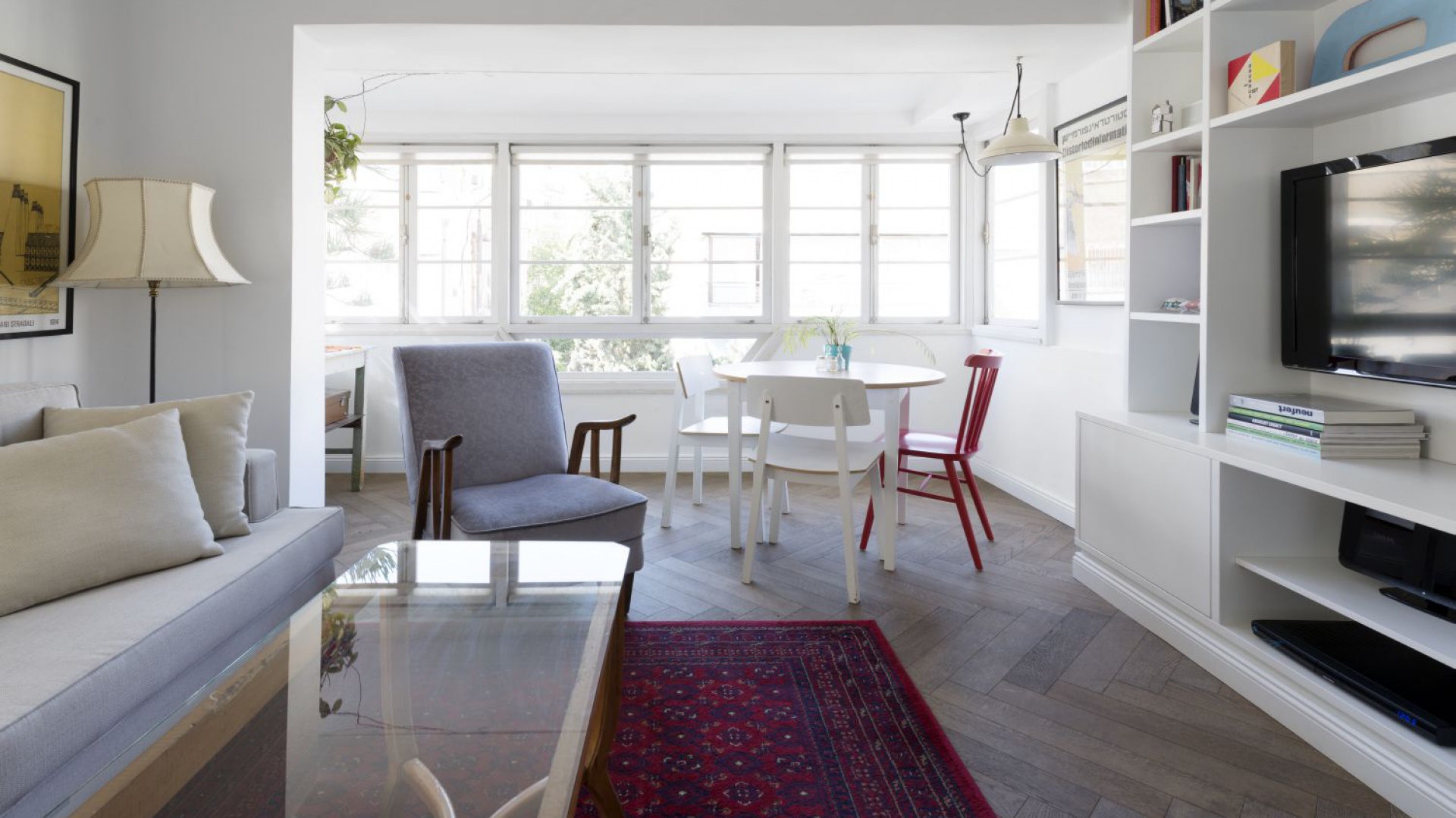 Podłogę w salonie i jadalni wykończono klasycznym, drewnianym parkietem, który pięknie ociepla dominującą we wnętrzach biel. Projekt: Studio Raanan Stern. Fot. Gidon Levin.