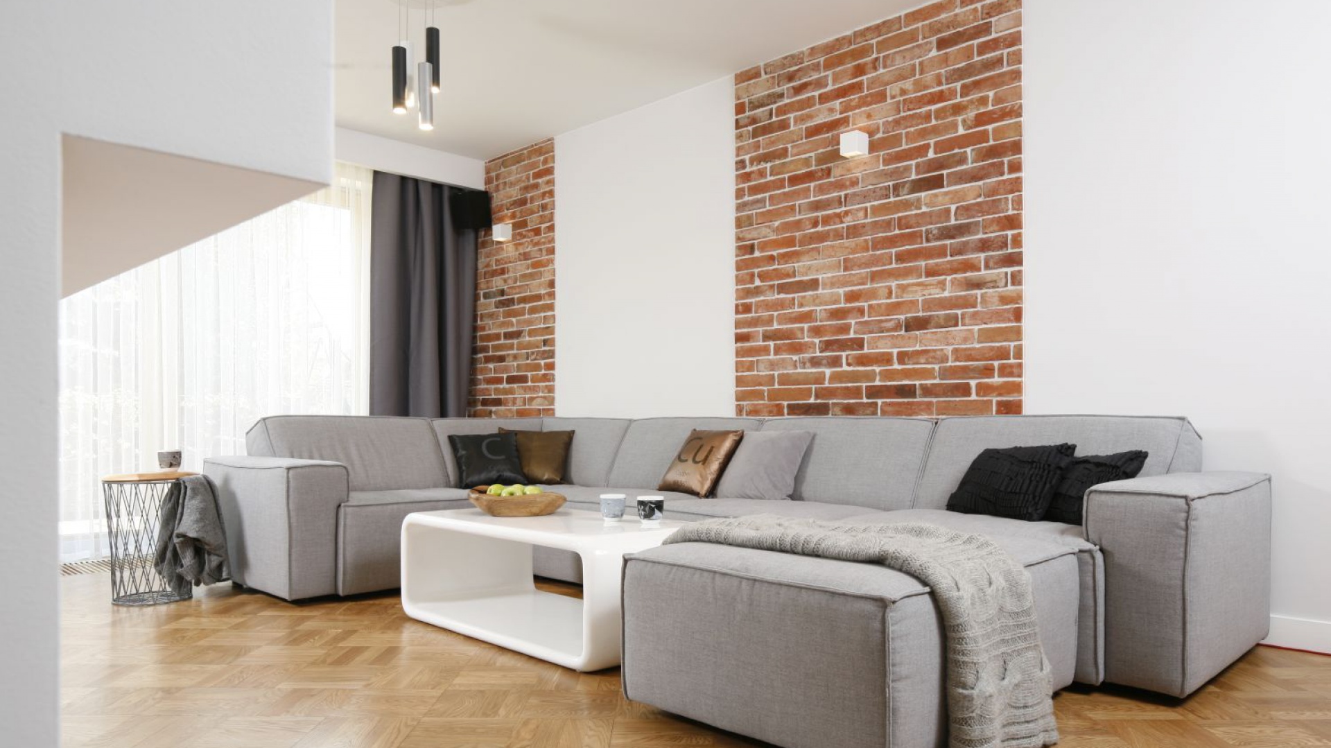 Pionowe pasy z cegły, będące główną dekoracją salonu wizualnie poszerzają długie wnętrza. Projekt: inż. arch. Agata Piltz. Fot. Bartosz Jarosz.