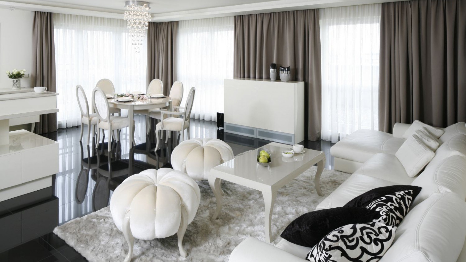 W otwartej strefie dziennej niepodzielnie rządzi styl glamour: eleganckie formy, błyszczące powierzchnie, zdobne kryształki oraz biel. Projekt: Katarzyna Uszok. Fot. Bartosz Jarosz.