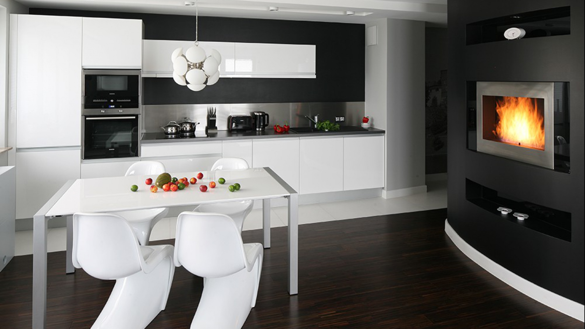 Aranżacja kuchni jest minimalistyczna, z paletą kolorów ograniczonych do bieli, czerni i metalicznej szarości. Projekt Studio Formy. Fot. Archiconnect.pl