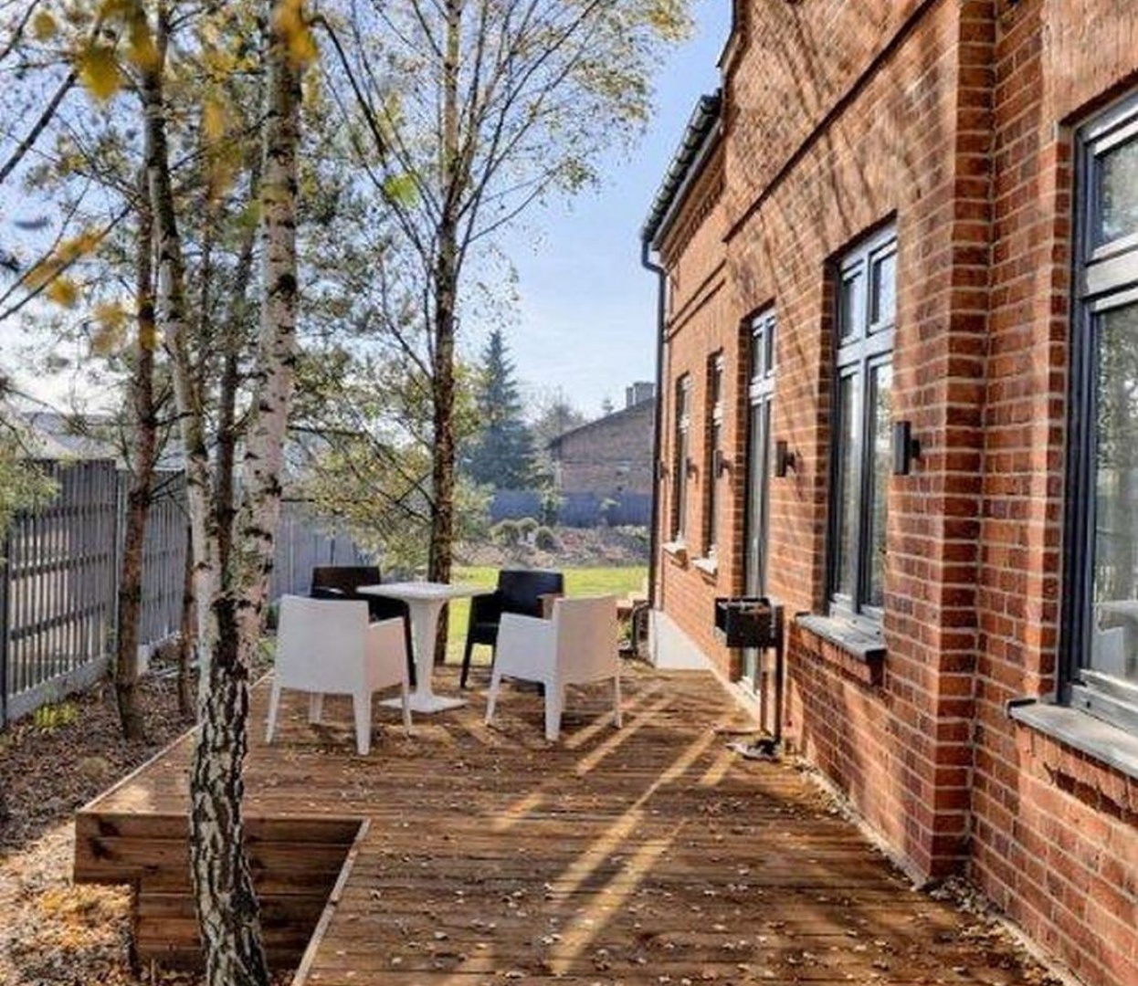 Minimalistyczny taras przy domu z cegły. Projekt Reform Property.jpg