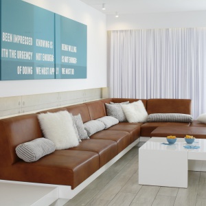 Na wskroś nowoczesne wnętrze salonu zdominowała duża kanapa narożna. Projekt: Dominik Respondek. Fot. Bartosz Jarosz