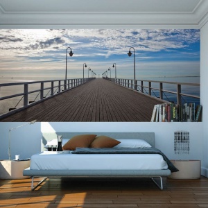 Ścianę nad łóżkiem pokryto efektowną fototapetą z pięknym widokiem na molo nad morzem. Fot. Dekornik