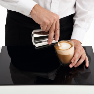 Serce - krok drugi.  Gdy  filiżanka jest już do połowy pełna, zbliż dzióbek do powierzchni kawy bez zmiany tempa nalewania mleka, tak by uzyskać biały okrągły kształt. Fot. Philips