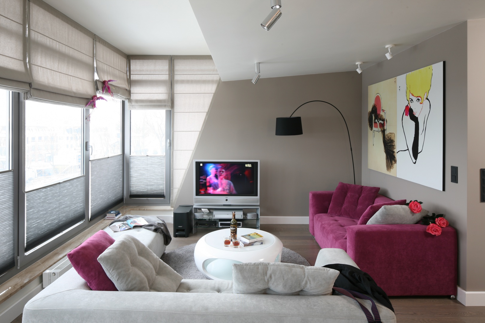 Salon ma charakter nowoczesny, ale nie brakuje w nim elementów stylu glamour jak np. różowe kanapy. Projekt: Małgorzata Borzyszkowska. Fot. Bartosz Jarosz
